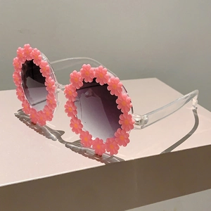 Detail view of children's daisy sunglasses with pink floral frame and gradient lenses