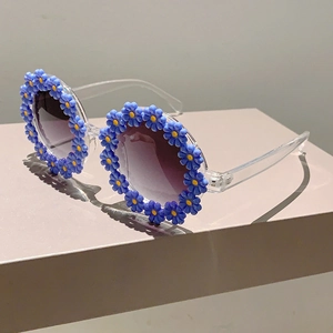 Close-up of kids flower sunglasses with blue daisy decorations and gradient lenses