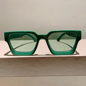 Vue détaillée de face des lunettes de soleil carrées vertes avec verres teintés assortis