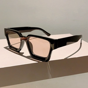 Détail de lunettes de soleil carrées à monture noire et verres teintés sur socle