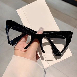 Detail of hand-held black glossy cat-eye glasses frame with clear lenses in a retro style