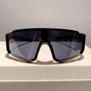 Vue de face des lunettes de soleil de sport noires avec écran large sur un support