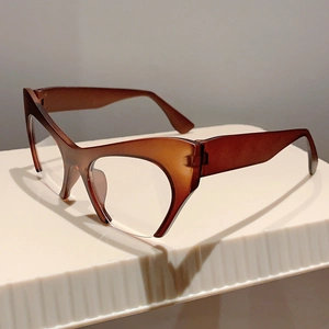 Detail of vintage cat-eye glasses with semi-transparent amber frame on a white stand