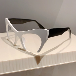 Side view of chic cat-eye half-frame glasses in black and white on a textured pedestal