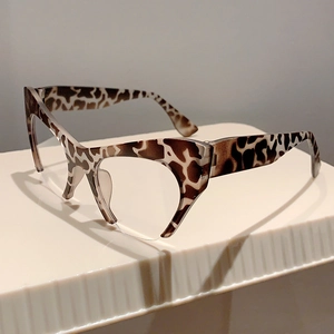 Detailed top view of cat-eye half-frame glasses with brown leopard pattern on a white stand