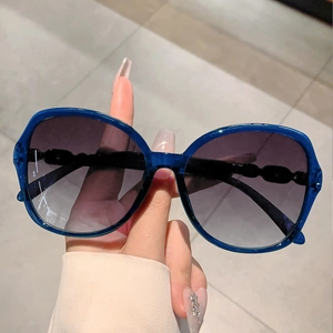 Close-up of stylish navy blue translucent frames with gradient purple lenses and chain detail