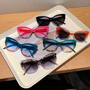 Set of six trendy cat-eye sunglasses in various gradient colors on white tray