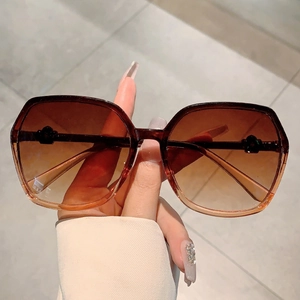 Macro shot of oversized retro sunglasses with brown gradient lenses and translucent frames