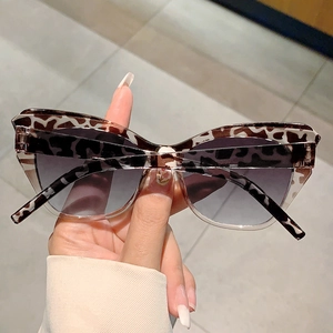Detail of cat-eye sunglasses with leopard print frame and grey gradient lenses
