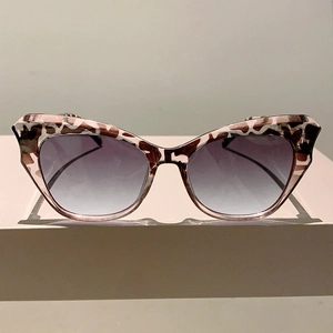 Detail of cat-eye sunglasses with tortoise frame and purple gradient lenses
