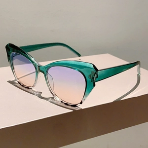 Detailed view of green cat eye sunglasses with purple to orange gradient lenses