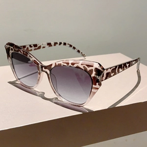 Detailed view of cat eye sunglasses with giraffe pattern frame and gradient grey lenses