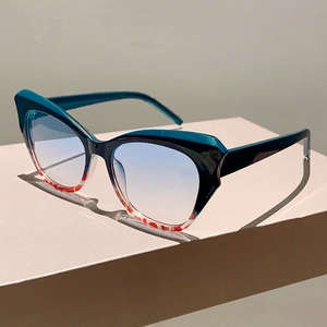 Close-up of cat-eye sunglasses with green frame and red marbled patterns on base