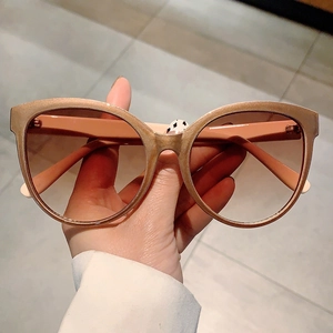 Detail of champagne gold glitter cat eye frame and brown gradient lens sunglasses