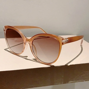 Detail of amber cat-eye sunglasses featuring gradient brown lenses on stone display