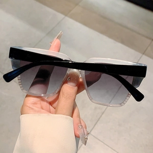Detailed close-up of fashion oversized square sunglasses with black frames and gradient lenses