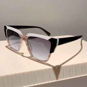 Detail view of square oversized sunglasses with black white color blocking and striped bridge