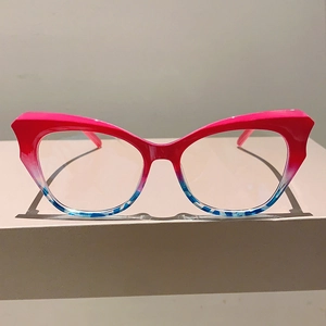 Detailed view of red and blue cat-eye glasses frame with color-blocking gradient