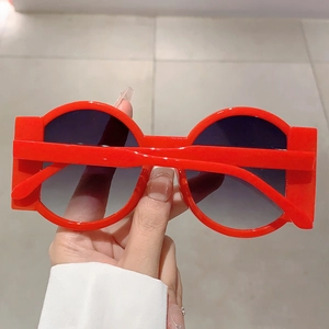 Macro shot of red avant-garde oversized sunglasses with round lenses and side wings
