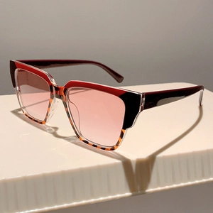 Detail of oversized color-block sunglasses with burgundy and tortoiseshell frame design