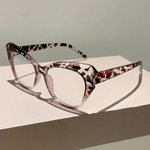 Close-up of cat-eye frames with stylish tortoiseshell patterns on a white podium