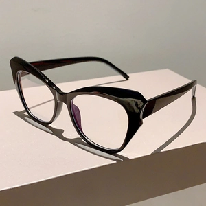 Close-up of black cat-eye glasses frame with clear lenses on white display stand
