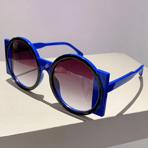 Detail of blue round sunglasses featuring thick frames and gradient purple lenses