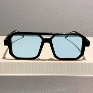 Detail of square black frame sunglasses with light blue lenses and double-bridge design