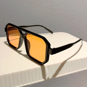 Detail view of retro double bridge rectangle sunglasses with orange tinted lenses
