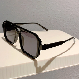 Detail of classic black square sunglasses featuring a double bridge and thick frame