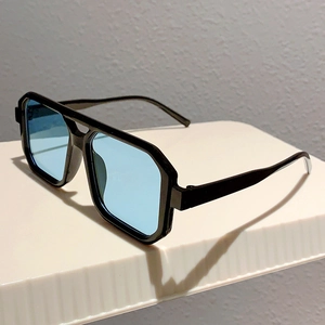 Detail of square black frame sunglasses with blue gradient lenses and double bridge design