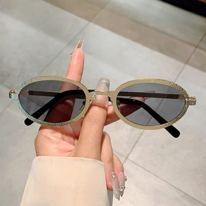 Retro oval sunglasses with embossed gold metal frames and dark lenses for women