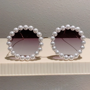 Detailaufnahme der runden Sonnenbrille mit perlenbesetztem Rahmen und Verlaufsgläsern