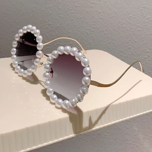 Detailansicht der Rundrahmen-Sonnenbrille mit Perlenbesatz und gewellten Goldbügeln
