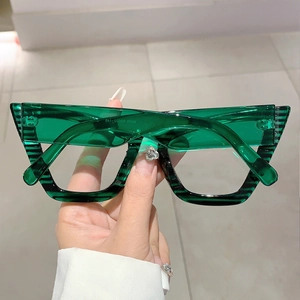 Detailed view of dark green cat-eye frame glasses with striped pattern on the temple