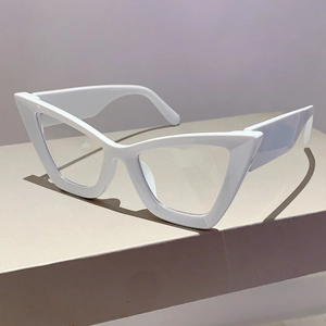 Detailed view of white cat-eye glasses with oversized retro frame on a minimal pedestal