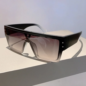 Detail of square oversized sunglasses showing silver metal rivets and gradient lenses