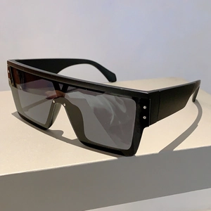 Detailed close-up of oversized flat top shield sunglasses with silver metal rivets