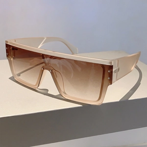Detail view of champagne square sunglasses with brown gradient lenses and silver rivets