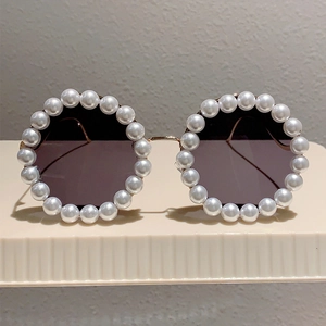Retro-Sonnenbrille mit runden, perlenbesetzten Rahmen und eleganten goldenen Bügeln