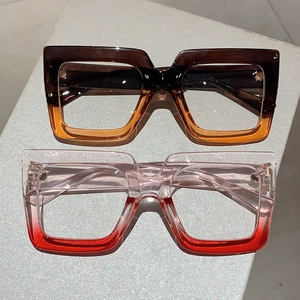 Modern oversized square eyewear with gradient amber and pink frames on stone pedestals