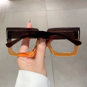 Detail of square gradient eyeglasses with brown amber frames and gold metal hinges