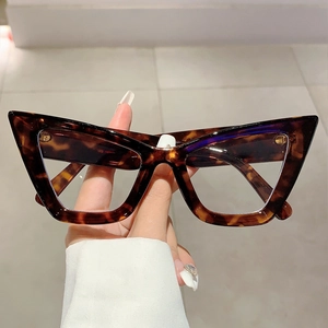 Handheld view of oversized tortoiseshell cat-eye glasses with anti-blue light lenses