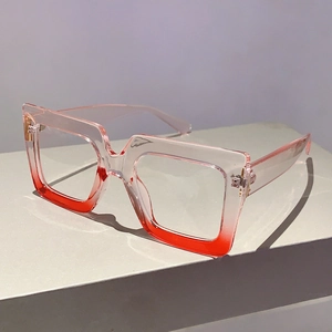 Close-up of square glasses frames with pink to red gradient and transparent temples