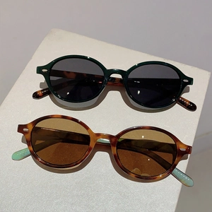 Vintage oval sunglasses set in dark green and tortoiseshell frames with UV protection