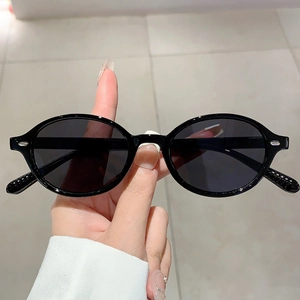 Detail of vintage oval sunglasses with a sleek black frame and dark protective lenses