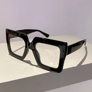 Detail of glossy black square frames with thick acetate temples and metal hinges
