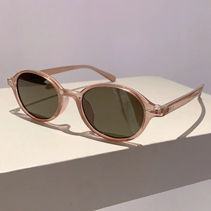 Detail of pink transparent acetate sunglasses frame with metal hinges on white block