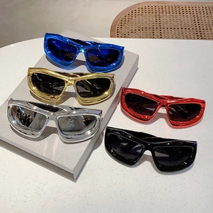 Close-up of Y2K wraparound sunglasses showing metallic blue, gold, silver, red, and black frames