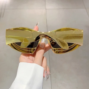 Detailed close-up of glossy gold metallic frame and seamless futuristic Y2K style sunglasses